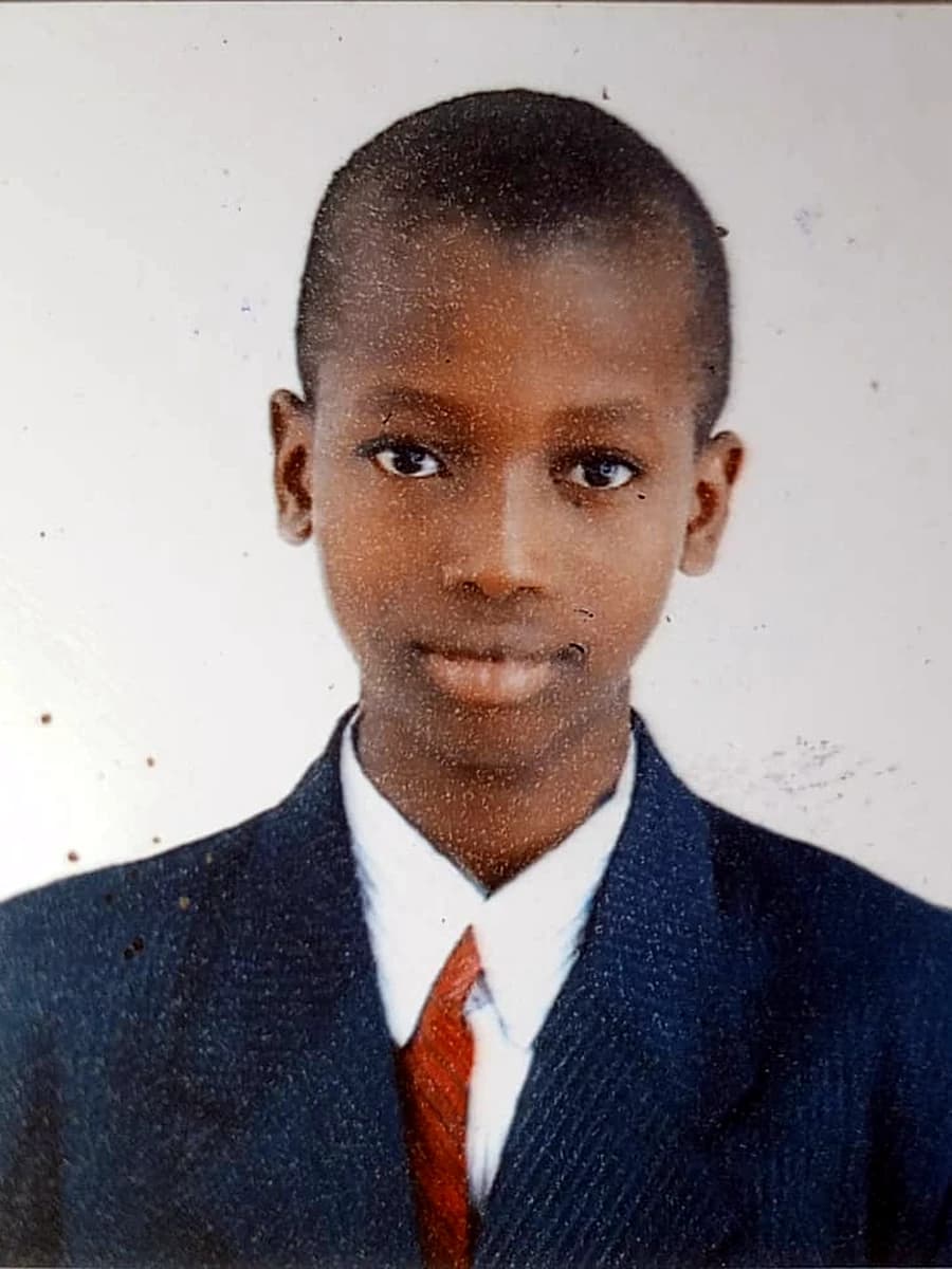 Abdulsalam as a boy, in a navy jacket and a red tie